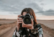 Best Digital Cameras Under $300 A young woman using a DSLR camera