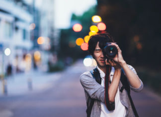 Best cameras for night photography in 2023 A young Japanese man is taking photos at night in Tokyo