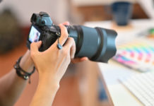 Best Zoom Cameras in 2023 Close up Cameraman checking with professional camera Photography Photographer working in creative workplace.