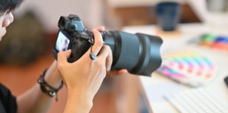 Best Zoom Cameras in 2023 Close up Cameraman checking with professional camera Photography Photographer working in creative workplace.