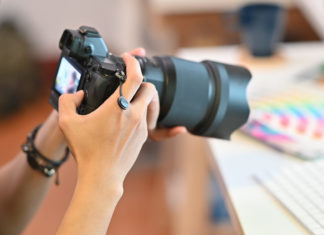 Best Zoom Cameras in 2023 Close up Cameraman checking with professional camera Photography Photographer working in creative workplace.