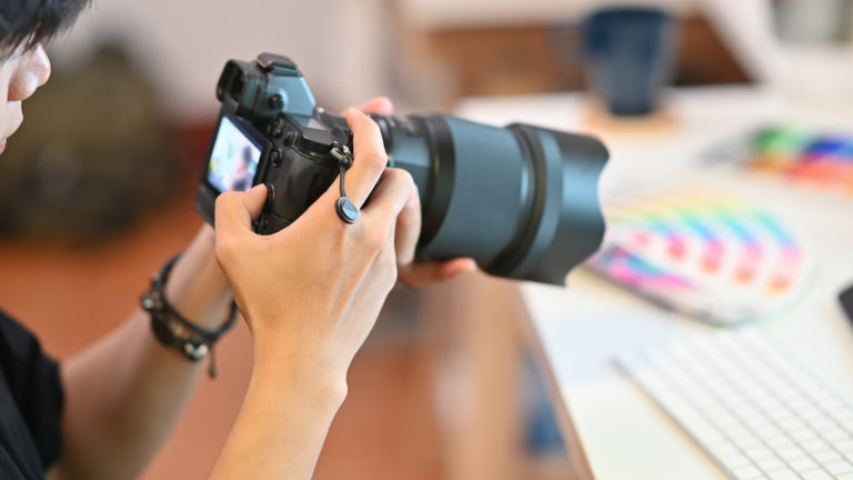 Close up Cameraman checking with professional camera Photography Photographer working in creative workplace.