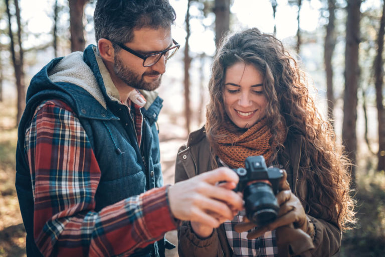 Photo of young couple with beginners camera in nature