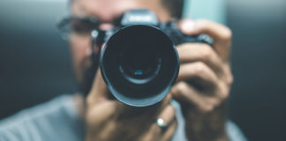 Best Cameras Under $700 in 2023 man using a digital camera worth $700 and pointing it