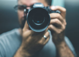 Best Cameras Under $700 in 2023 man using a digital camera worth $700 and pointing it