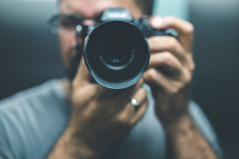 man using a digital camera worth $700 and pointing it