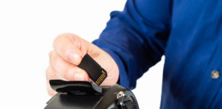 Best Memory Cards for Your Camera Image contains a man inserting a memory card into his camera.